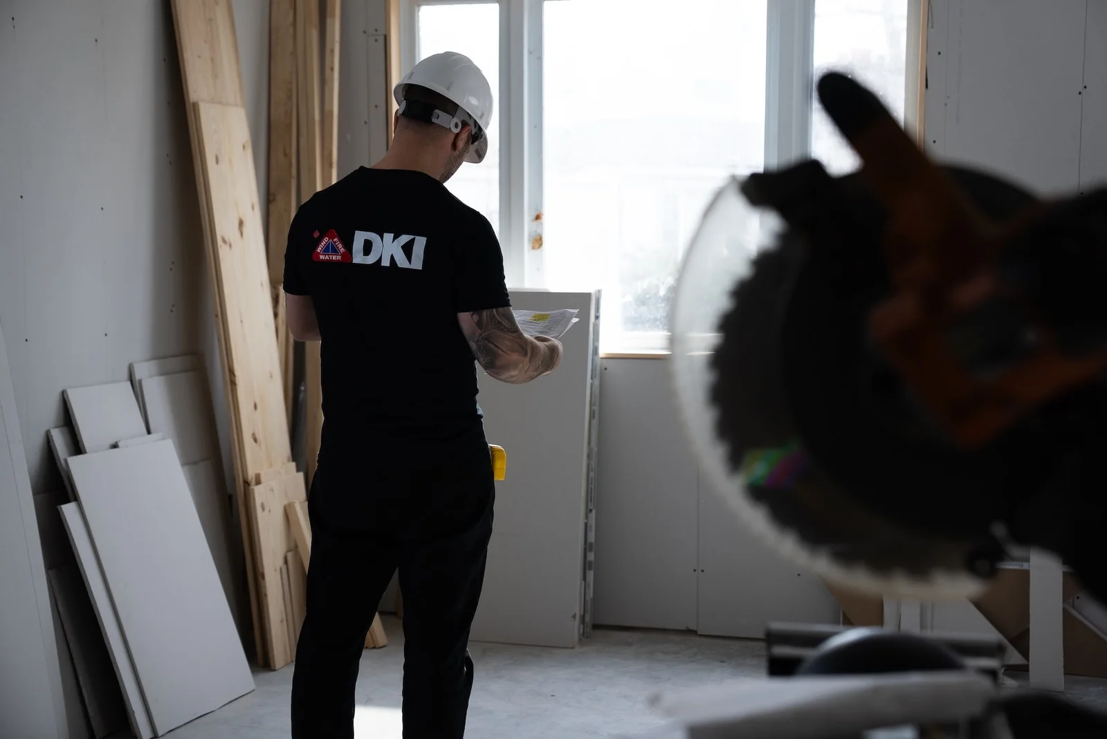 DKI Miller crew member reviewing plans in a home under restoration